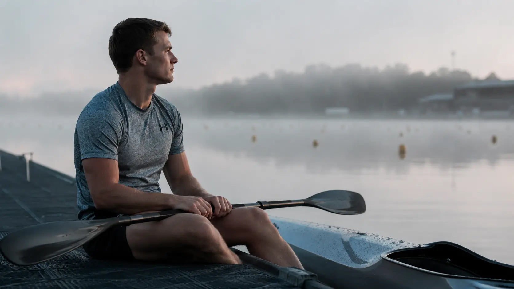 Competitive kayaker focusing at the start line, illustrating the mental preparation required for sprint racing