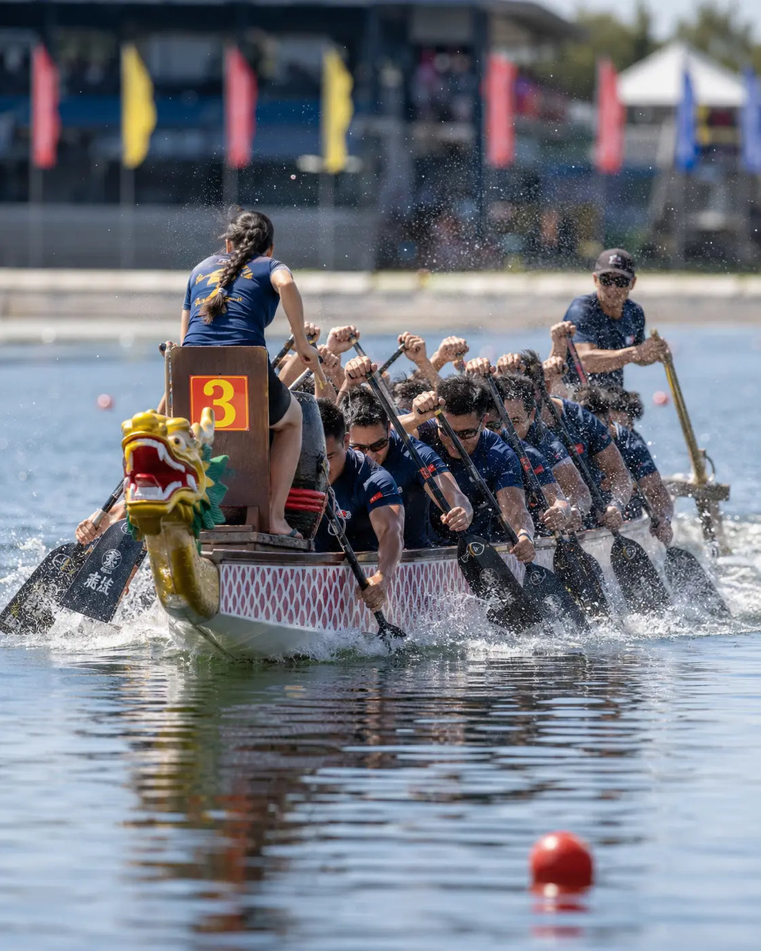 Dragon boat team of paddlers racing in synchrony during a competitive dragon boat race