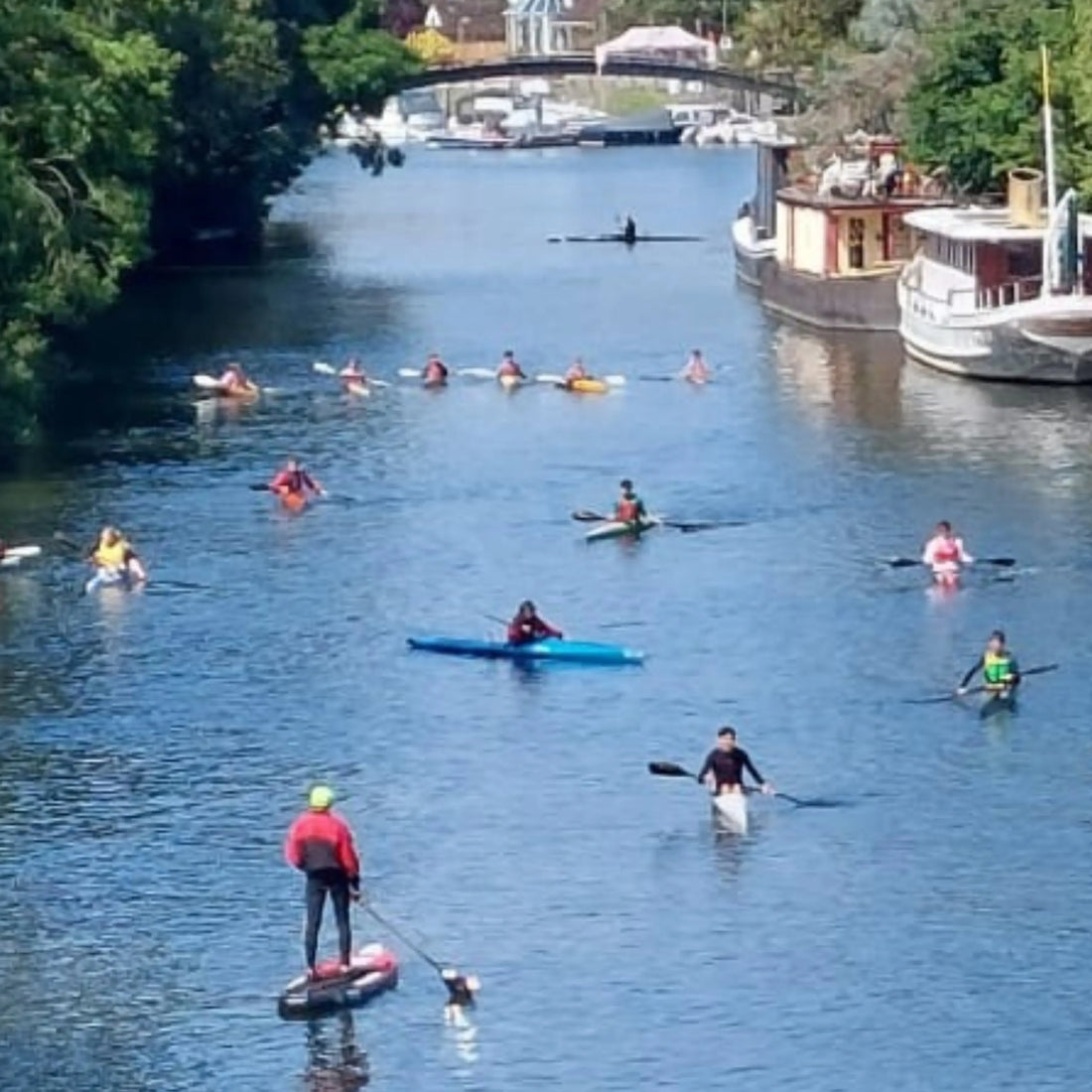 Kayakers and a stand-up paddleboarder on the River Thames, the kind of paddlers this kayaking gifts guide is for