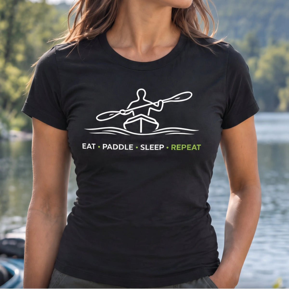 Woman wearing the Eat Paddle Sleep Repeat DRIFT Vector fitted tee in Black by a lake — white line-art kayaker design — Vector Paddle