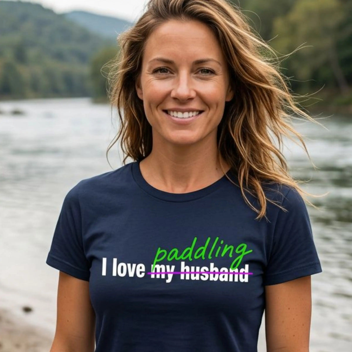 Woman wearing the I Love Paddling fitted tee in Navy by a river — "I love my husband" crossed out for "paddling" — Vector Paddle